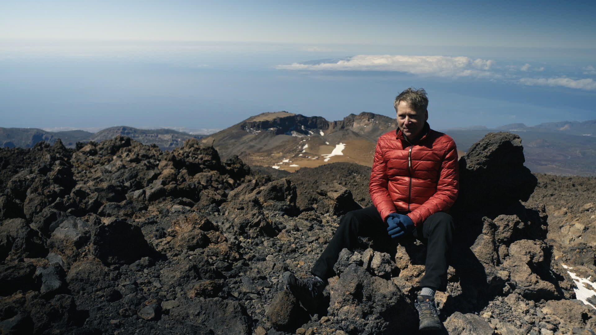 Volcanologist on the volcanic summit above the clouds